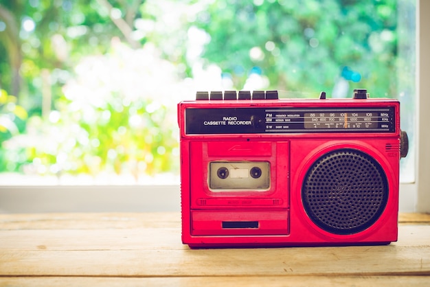 Retro de color rojo de la radio en la mesa con la naturaleza de fondo, el filtro de cosecha de color