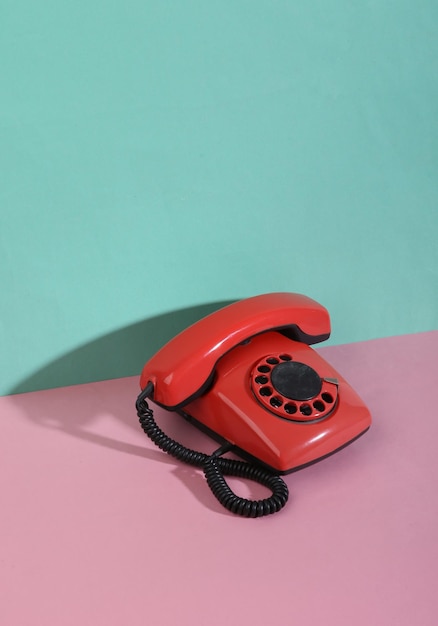 Retrô criativo dos anos 80 ainda vida telefone rotativo retrô em fundo pastel azul rosa minimalismo sombra na moda