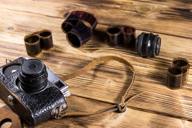 Retro-Fotokamera mit Fotofilm und Objektiv auf Holztisch