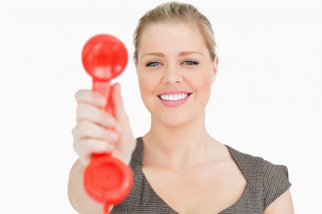 Retro- Telefon rot in einer Hand einer hübschen Frau