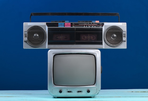 Retro-TV-Empfänger mit Tonbandgerät auf klassischem Blau. Retro-Medien