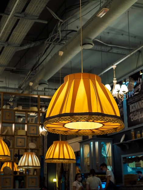 Retro-Vintage-Lampen mit großen gelben Lampenschirmen im Café-Interieur