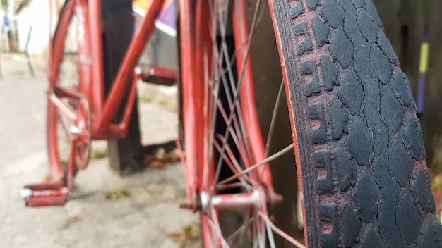 Retro Vintage rotes Fahrrad hautnah. Ein altes charmantes Konzept eines klassischen verlassenen Fahrrads.