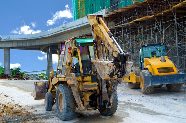 Retroescavadeiras em pé no local de construção de rodovia