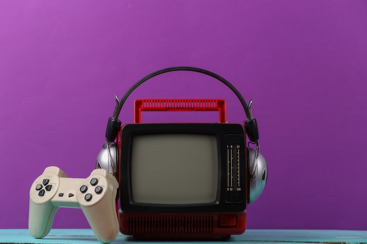 Foto retrogaming. competição de videogame. tv antiga com fones de ouvido e gamepad em fundo roxo. atributos anos 80