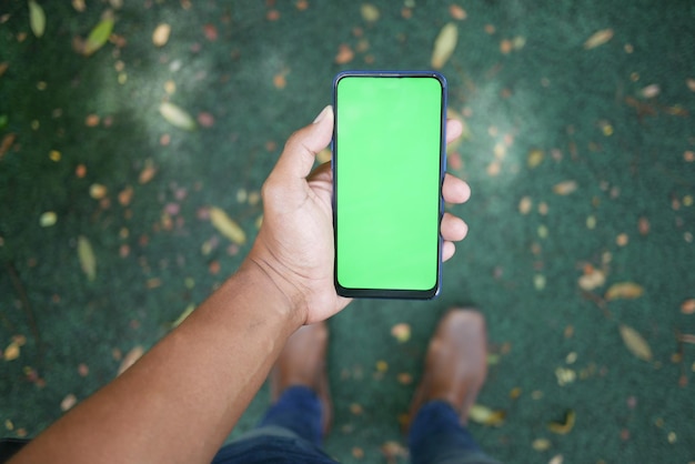 Retrovisor de jovem usando telefone inteligente ao ar livre