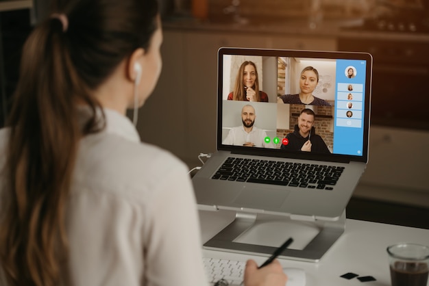 Foto retrovisor de uma empresária em casa em uma videoconferência com seus colegas durante uma reunião on-line. parceiros em uma vídeo chamada. equipe de negócios multiétnico, tendo uma discussão em uma reunião on-line.