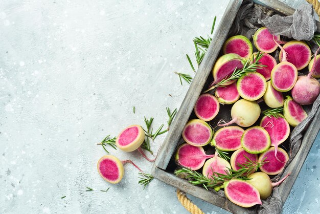 Rettich-Wassermelone in einer Box Gesunde Gemüse-Diät-Lebensmittel Freier Platz für Text auf Steinhintergrund