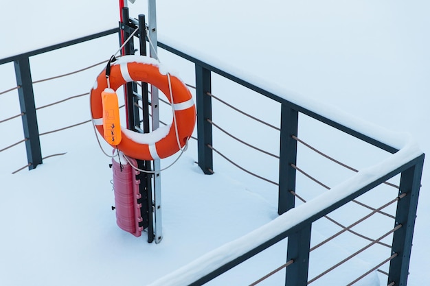 Rettungsring bei Winterwetter Rettungsring mit weißem Schnee bedeckt Winter-Rettungsgeräte gefroren Rettungsring für Ihre Sicherheit Sicherheitskonzept