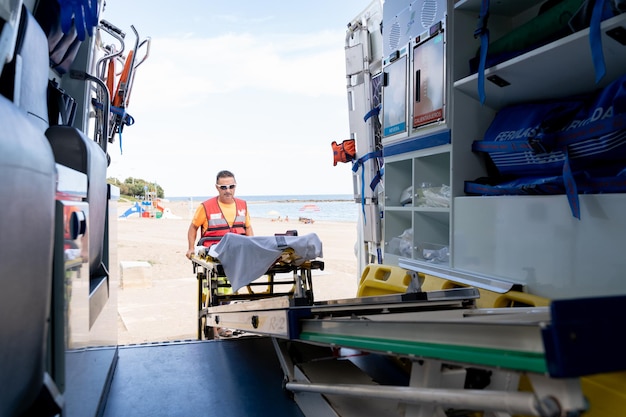 Rettungsschwimmer, der an einem Krankenwagen am Strand arbeitet