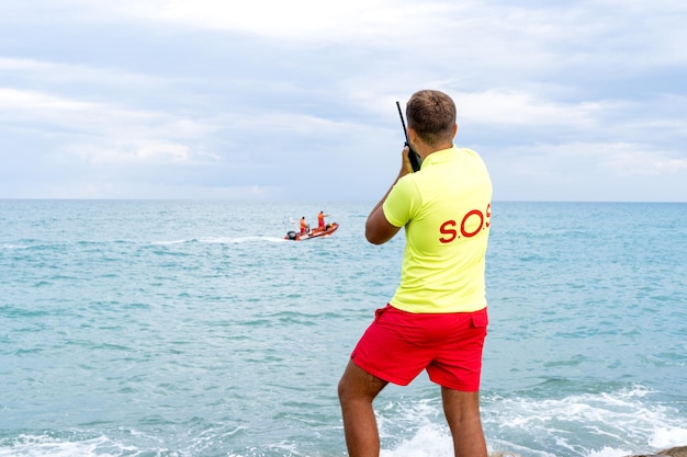 Rettungsschwimmer spricht per Funk mit einem Rettungsboot