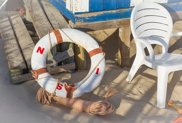 Rettungsschwimmer und Seile in der Nähe des hölzernen Rettungsschwimmerturms an einem Sandstrand.