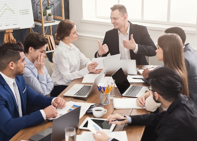 Reunião corporativa de negócios da equipe de sucesso. Jovens alegres fazendo um brainstorming, discutindo um novo projeto de inicialização no escritório, copiando o espaço