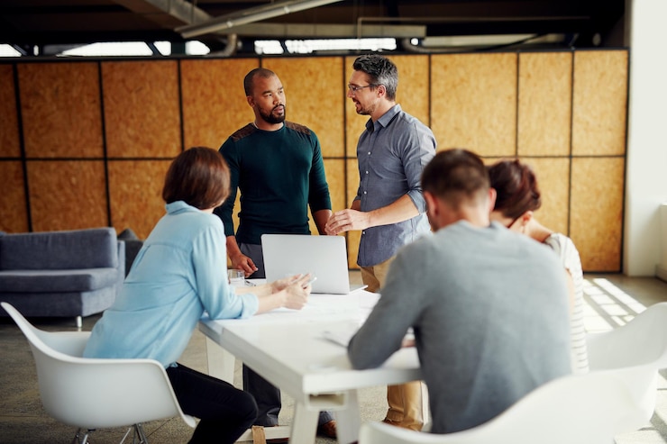 Foto reunião da equipa e do portátil no escritório para discussão, aconselhamento e revisão do desempenho à mesa; parceiros de proposta ou computador no local de trabalho para planeamento de feedback ou líder para resolução de problemas no projecto;
