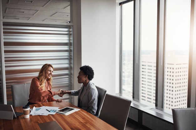 Reunião de aperto de mão ou pessoas de negócios no escritório com documentos tablet ou acordo de orçamento Entrevista de emprego de recrutamento e mulher apertando a mão com HR para contrato de contratação ou sucesso de negócio de terceirização