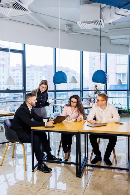 Reunião de empresários, discutindo novas idéias de negócios, usando diagramas, sentados juntos. Fundo de escritório moderno. Reunião de parceiros de negócios em uma conferência de desenvolvimento de negócios