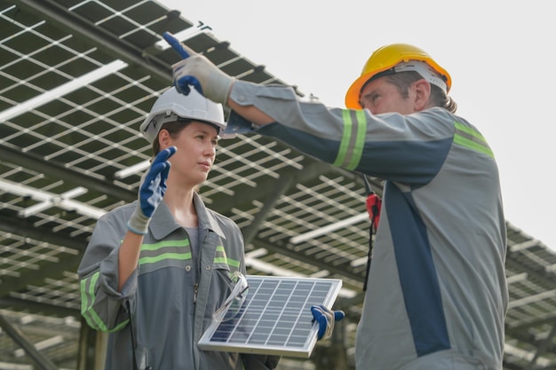 Reunião de engenheiros para verificar o painel solar no telhado da fazenda solar com um sistema de armazenamento de energia operado pela Super Energy Corporation. Especialistas reunidos para testes ao ar livre Módulo de células fotovoltaicas