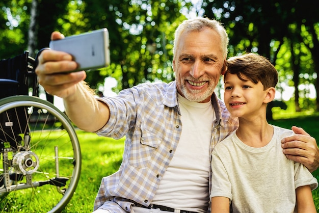 Reunião de família no parque. Menino e avô Selfie.