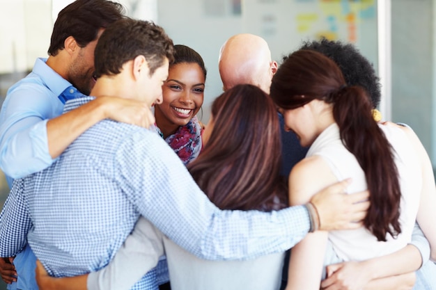 Foto reunião de formação de equipe e pessoas de negócios em círculo de confiança para colaboração de suporte e planejamento no escritório amigos de trabalho e abraço pela equipe com diversidade na reunião para visão de meta e plano de inicialização