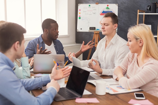 Reunião de negócios da jovem equipe multiétnica. discussão do novo projeto no escritório, chefe afro-americano se comunicando com os sócios no escritório, copie o espaço