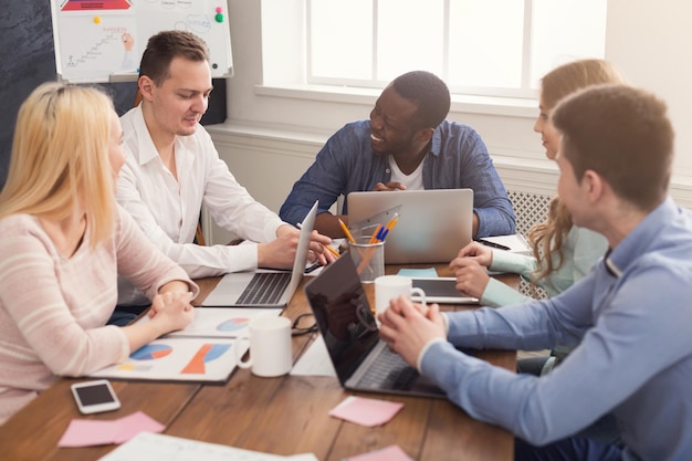 Reunião de negócios da jovem equipe multiétnica. Discussão do novo projeto no escritório, chefe afro-americano se comunicando com os sócios no escritório, copie o espaço