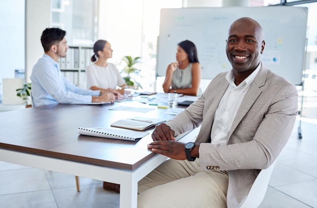 Reunião de negócios do homem negro e retrato na inicialização do escritório e planejamento do trabalho em equipe na empresa corporativa Sorriso feliz e visão do empresário executivo à mesa com meta de motivação e inovação