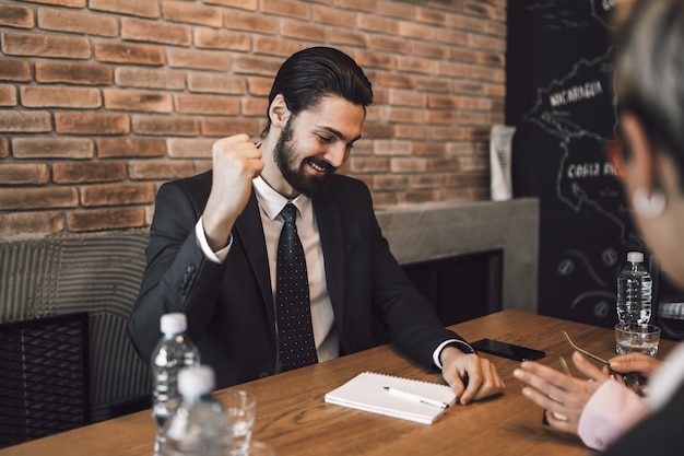 Reunião de negócios. Feliz empresário comemorando após uma conversa de negócios de sucesso.