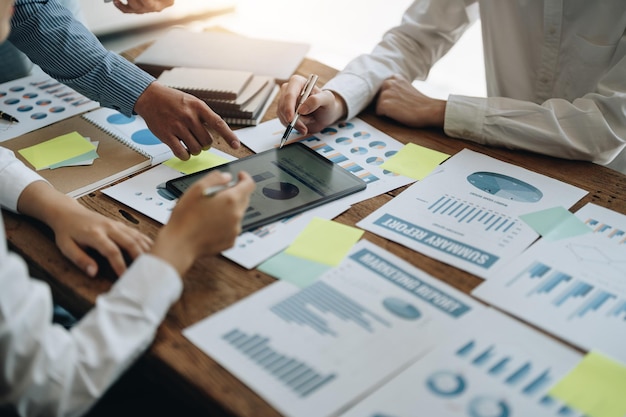 Reunião de pessoas de negócios usando papel de gráfico de mercado laptop calculadoranotebookstock para análise Planos para melhorar a qualidade no próximo mês Discussão da Conferência Conceito Corporativo