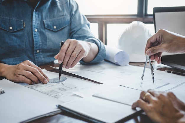 Reunião de trabalho em equipe de engenheiro, desenho trabalhando na reunião de planta para o projeto que trabalha com o parceiro