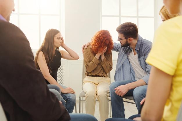 Reunião do grupo de apoio. Mulher jovem desesperada chorando durante a terapia de grupo de reabilitação. Psicoterapia, depressão, conceito de problemas de vida