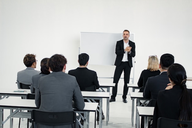 Reunião e planejamento de trabalho em equipe junto a asiáticos e estrangeiros em sala branca. Conceito de trabalho em equipe.