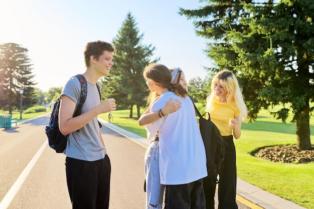 Reunión de amigos adolescentes sonrientes en un parque soleado de verano