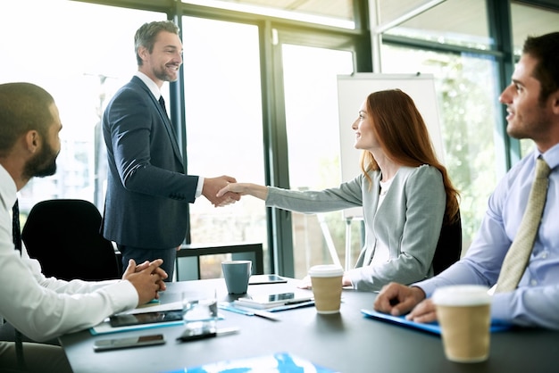 Reunión de apretón de manos y éxito con personas de negocios en la sala de juntas de la oficina para bonificación o promoción Felicitaciones acuerdo o gracias con empleado hombre y mujer estrechando la mano en el trabajo para el acuerdo
