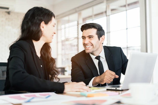 Reunión de consultoría de sociedades comerciales caucásicas con una sonrisa. Lluvia de ideas sobre la inversión financiera en nuevos proyectos comerciales para el éxito en la mesa de trabajo con una computadora portátil. Reunión interna en oficina.