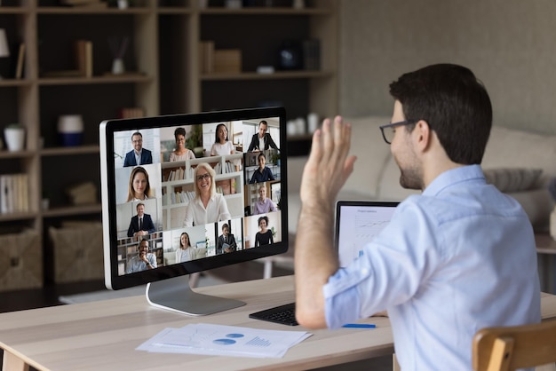 Reunión de empleados de la oficina del milenio hablando con el equipo de negocios en videoconferencia negociando con compañeros de oficina en chat de conferencia virtual en línea saludando con la mano en el monitor discutiendo el proyecto
