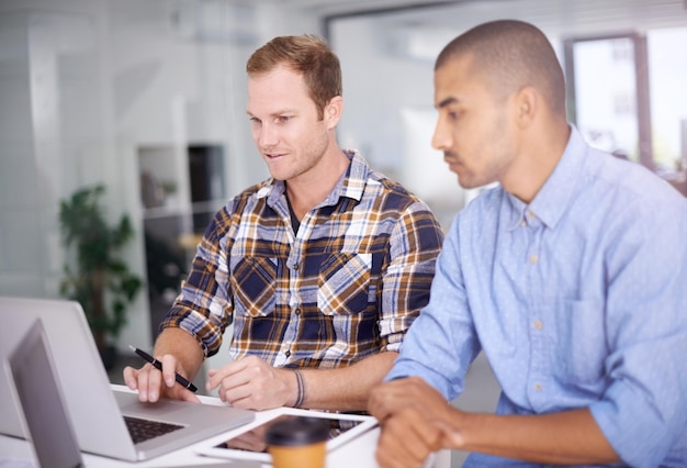 Reunión de la empresa y hombres de negocios con computadora portátil en la oficina creativa para la revisión o planificación del proyecto de trabajo en equipo Tecnología de diseño de interiores y empleados masculinos para la colaboración o discusión profesional
