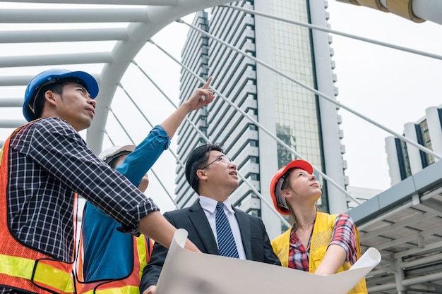 Reunión de empresario líder con el equipo de ingenieros hablando de la construcción del proyecto de informe de progresión