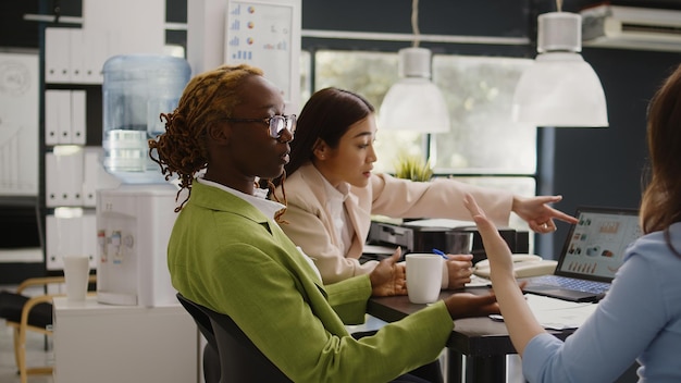 Reunión del equipo de negocios para discutir la estrategia de desarrollo en la oficina de la sala de juntas, intercambiar ideas sobre la visión de marketing y el crecimiento de las ganancias. Diversas personas hablando de proyecto ejecutivo.