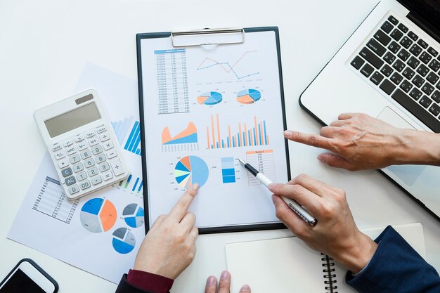 Reunión del equipo de negocios trabajando con un nuevo proyecto de inicio discusión y análisis de datos los gráficos y gráficos calculadora de tableta digital computadora portátil utilizando conceptos de finanzas y contabilidad de negocios