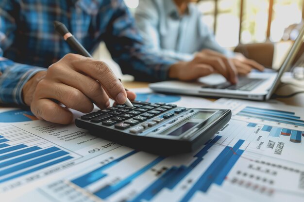 Reunión del equipo de negocios utilizando la calculadora de gráficos y analizando las estadísticas financieras de la estrategia de negocios