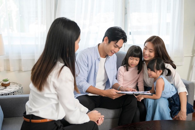 Reunión familiar asiática con agente inmobiliaria o consultora de seguros que ofrece promociones