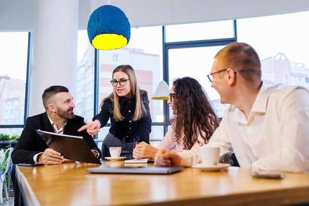 Reunión de gente de negocios, discutir nuevas ideas de negocios, usar diagramas, sentarse juntos. Fondo de oficina moderna. Reunión de socios comerciales en una conferencia de desarrollo empresarial