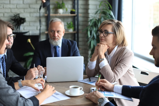 Reunión de intercambio de ideas de trabajo en equipo de hombres de negocios para discutir planes de inversión.