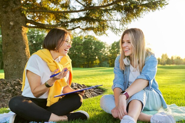 Reunión de maestra con estudiante joven al aire libre