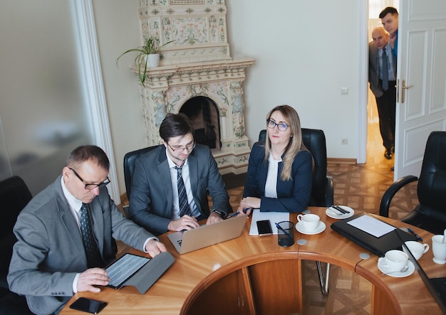 Reunión de mesa redonda de socios comerciales Equipo de personas de negocios que utilizan computadoras portátiles en la oficina