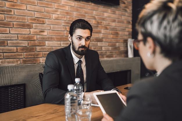 Reunión de negocios. Apuesto joven realizando una entrevista de trabajo.