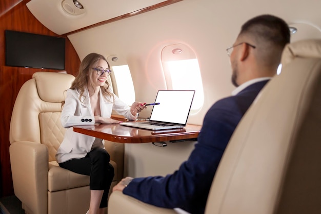 Foto reunión de negocios en avión mujer con traje y gafas discute el trato con el cliente y señala