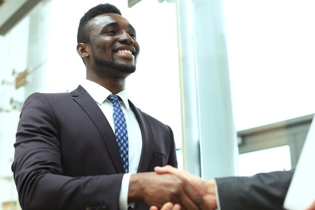 Reunión de negocios. Un hombre de negocios afroamericano estrechando la mano de un hombre de negocios caucásico.