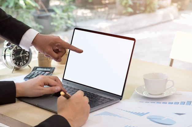 Reunión de negocios. Hombre de negocios que señala en la computadora portátil blanca de la pantalla en blanco a la explicación.