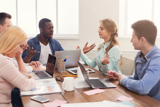 Reunión de negocios del joven equipo multiétnico. Discusión de la oficina del nuevo proyecto, jefe afroamericano comunicándose con socios en la oficina, espacio de copia